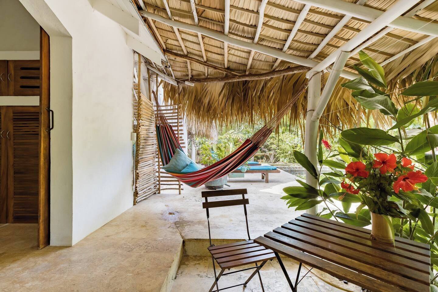 Casa Picaflor: covered outdoor lounge with a hammock and wooden benches