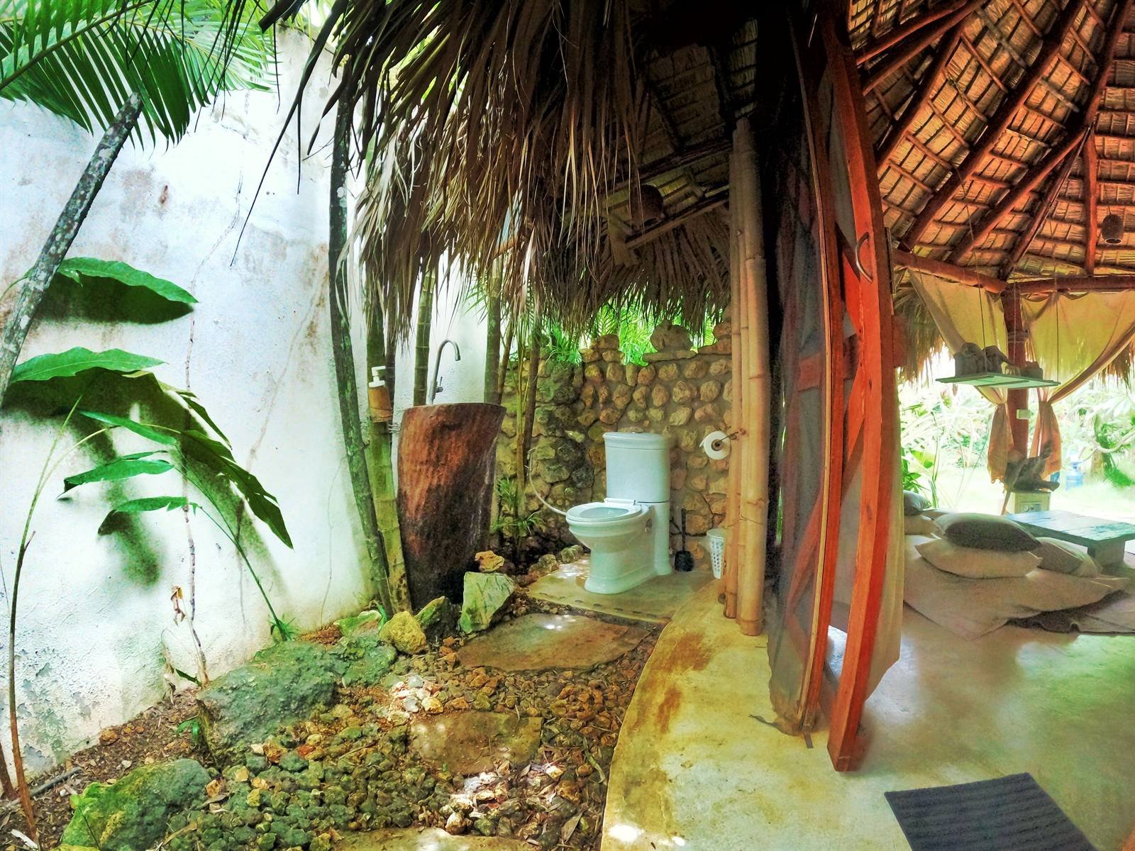 Casa Picaflor: rustic bathroom with a stone wall and a wooden vanity